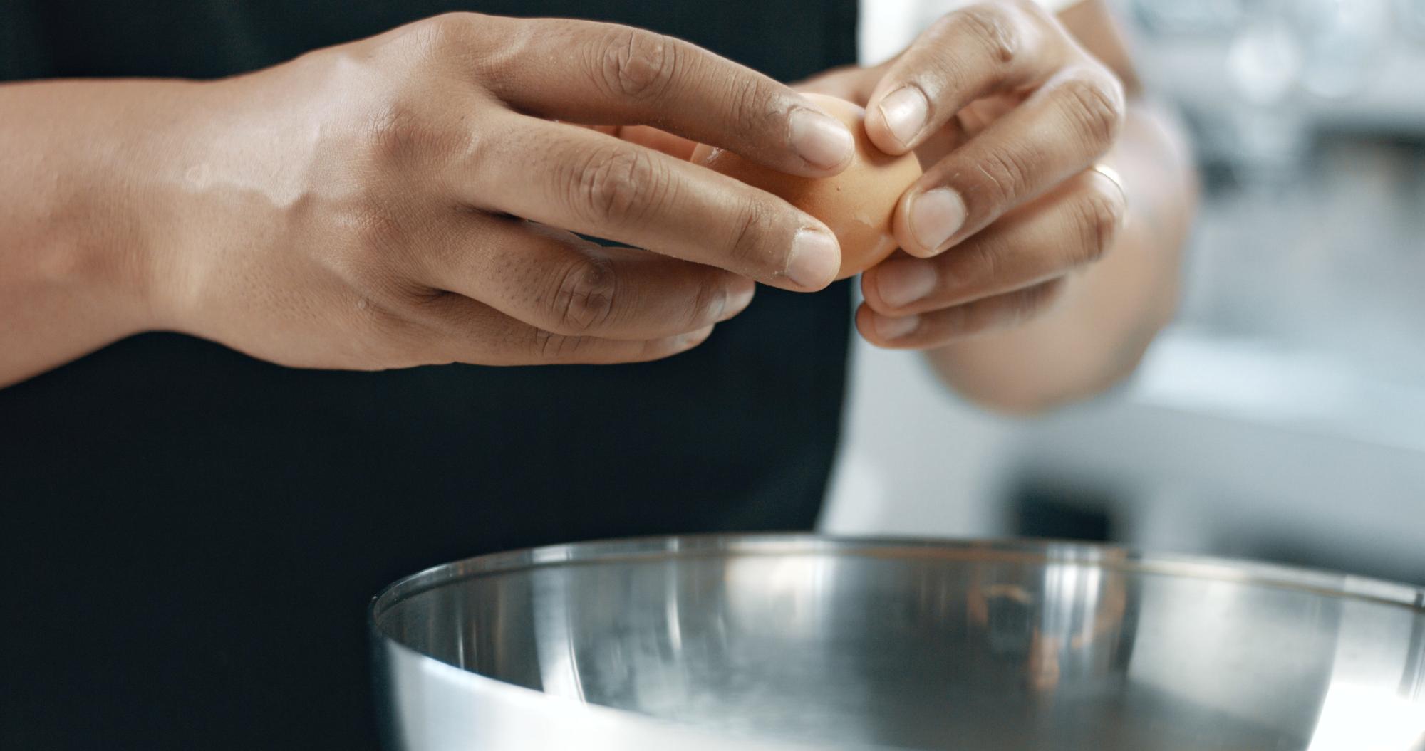Hands seasoning a protein precisely
