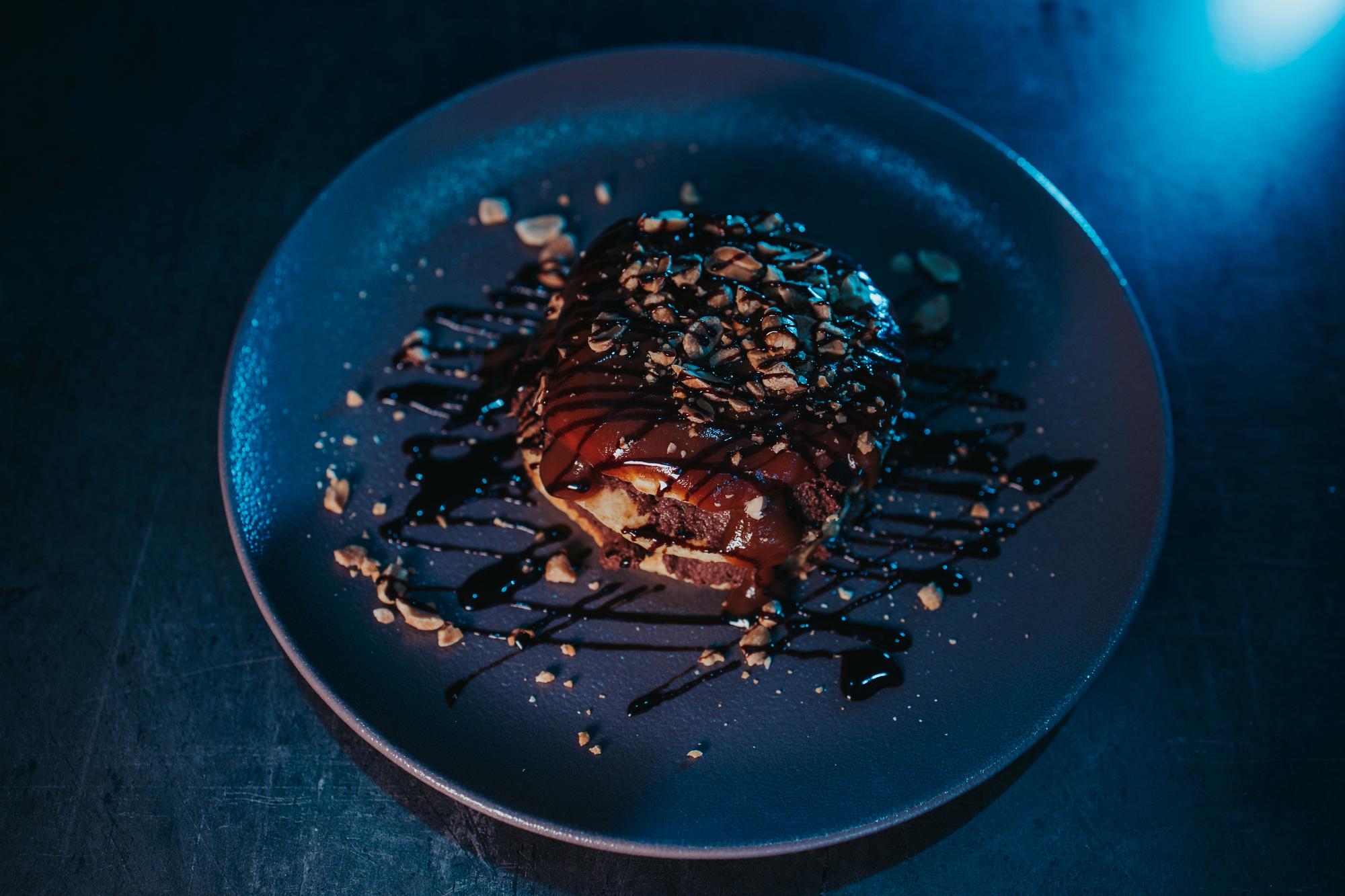 Slice of plated main course on a dark plate